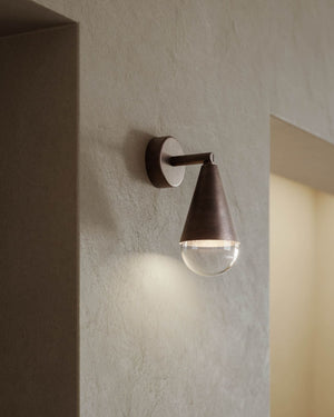 Adjustable Teardrop Wall Light displayed on a beige wall near a door
