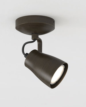 Dark bronze tilted ceiling spotlight mounted on a white ceiling