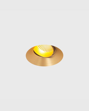 A modern recessed spotlight with a brushed brass circular frame, shown against a solid light gray background.