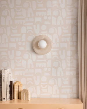 Alabaster dish sconce installed above a bookshelf