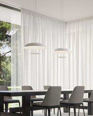 Two white aluminium disc pendant light suspended above a dining table in a minimal interior