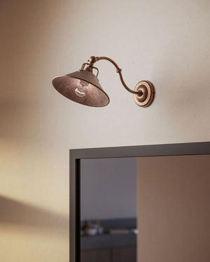 Brass Curved Fixed Arm Wall Light displayed over a mirror
