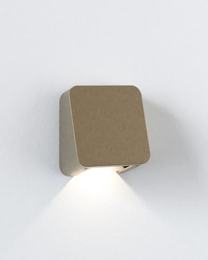 Brass square wall light fixture on a white background