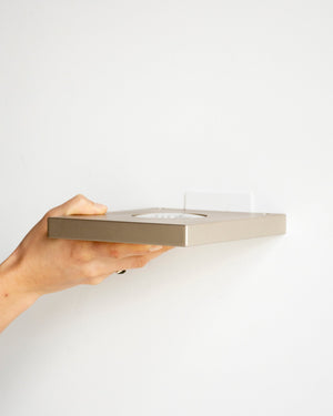 LED Ledge Wall Light in Bronze held by hand in Lighting Collective's Byron Bay Showroom 