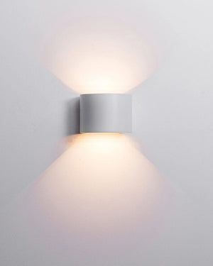 Rounded up & down wall light mounted on wall in white finish with wide beam angle