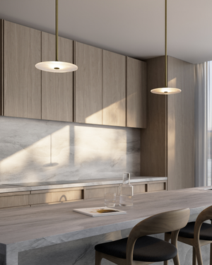 Modern kitchen with wooden cabinets, marble backsplash, and two glass pendant lights.