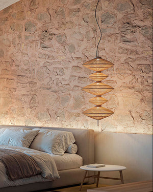 Modern bedroom with cotton hanging lights, stone wall and bed. Designed in Barcelona 