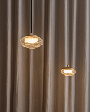 Two glass pendant lights hanging against a brown curtain background made in Sydney Australia