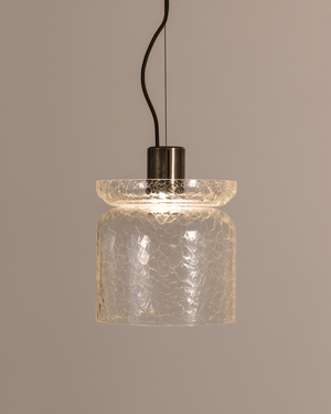 Pendant light with crackle glass shade on a neutral background