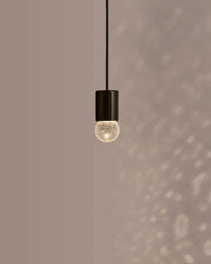 Pendant light with a textured bulb on a neutral background
