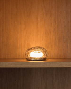 Crackle Glass table lamp on a wooden surface with a warm glow against a wooden background