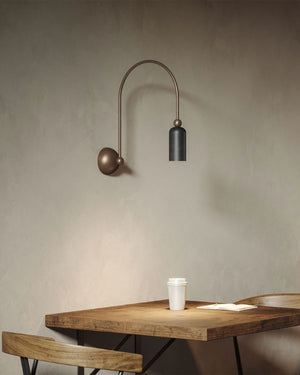 Dainty Brass Italian Wall Light | Grafene finish over a table in a cafe