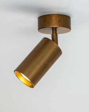 Directional Brass Ceiling Spotlight in antique brass mounted on white ceiling with head tilted at an angle