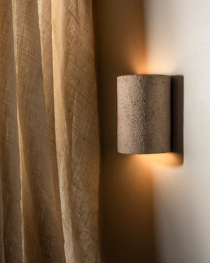 Ceramic rounded wall light with raw texture and finish