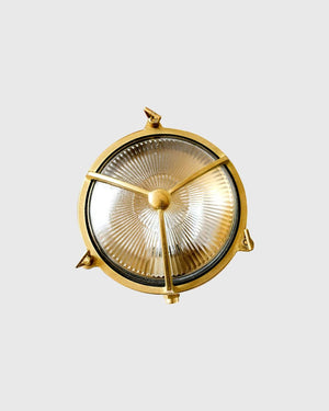 Brass bunker light in front of grey background