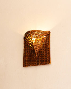 Flush fit woven rattan lighting mounted on a beige wall with warm light on