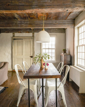 Rustic dining room with a white opal glass shade pendant suspended above a dark wooden table