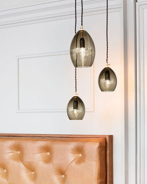 Three hanging pendant lights with smoked glass shades in a room setting.