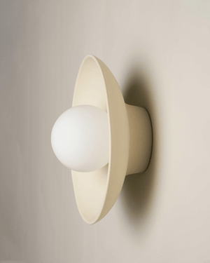 Beige wall-mounted light fixture with a white bulb on a beige background