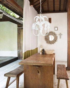 Coastal Chandelier Palm Springs style hanging over a rustic dining table 