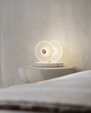 Modern lamp made in Australia on a bedside table with soft lighting, travertine base 