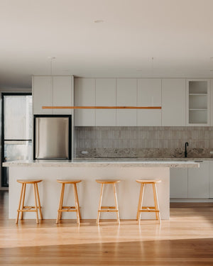 Timber ceiling light fixture hanging above marble island for minimalist kitchen lighting