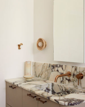 Timber wall sconce styled in a contemporary bathroom