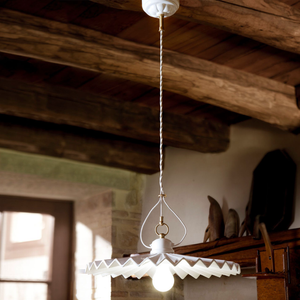 Pleated Plate White Glazed Ceramic Pendant suspended in a traditional living room with a wooden ceiling