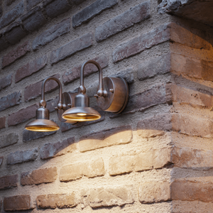 Aged Brass Curved Arm Wall Light Square on a brick wall