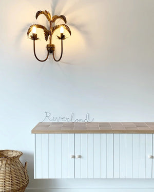 White cabinet with wooden countertop and wall-mounted light fixture against a white wall.