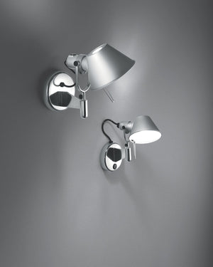 Two modern wall-mounted adjustable sconces with silver metal bases and shades, shown against a dark gray wall. 