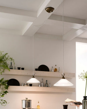 Double pendant light with brass and white glass materials hanging over a kitchen island