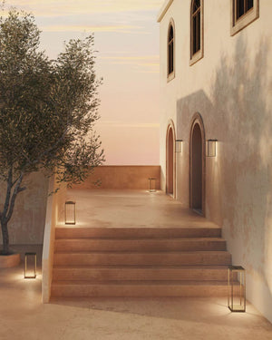 Italian Made Outdoor Lantern Floor Lamp in antique brass lighting a stone staircase and courtyard at dusk