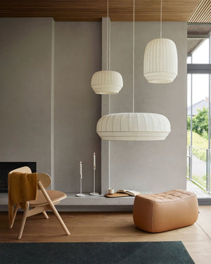 Modern living room with pendant lights, a chair, and an ottoman.