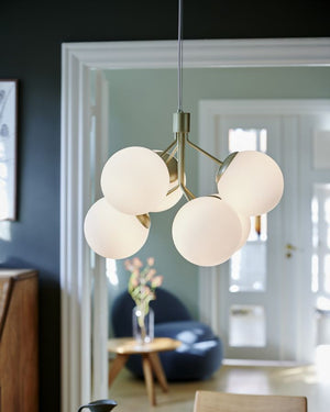 Brass Modern 6-Globe Chandelier hung in living area with navy walls 