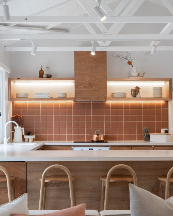 Track lighting in white suspended above kitchen area for warm focused light