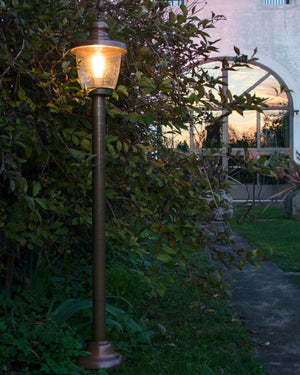Large traditional Ballard light in a garden when the sun sets down