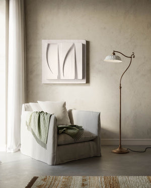 Classic perforated ceramic floor lamp displayed in a cosy reading nook