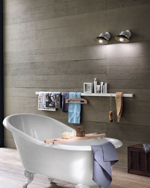 Two brass and white ceramic wall lights over a bath in a modern bathroom