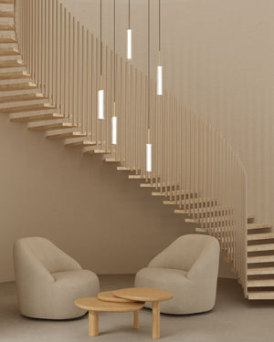 Modern interior with a staircase made of wooden slats, two beige armchairs, and a small wooden table.