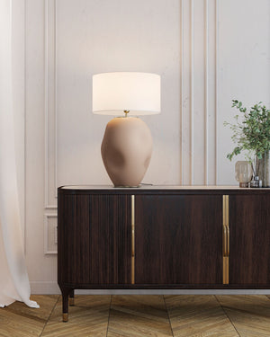 Modern sideboard with a lamp and decorative items in a stylish room.