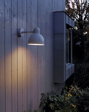 Outdoor wall light fixture on a wooden building exterior