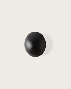 Black spherical wall light beige background