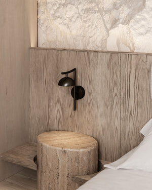 Minimalist Black Dome Wall Light next to a bed on a wall in a Scandinavian style room 