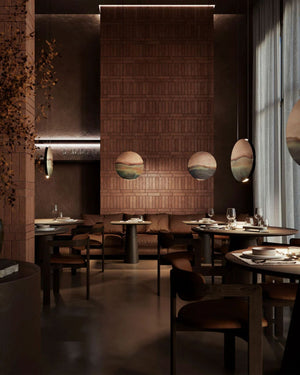 Mediterranean Marea Pendant Light cluster suspended above dining tables in dark restaurant interior with brick feature wall