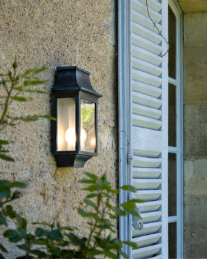 Lantern wall light in green patina finish on textured wall