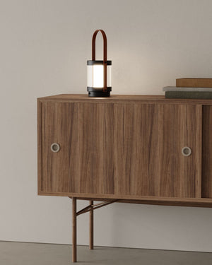 Wooden sideboard with a Minimalist Leather Portable Lamp on top against a plain wall