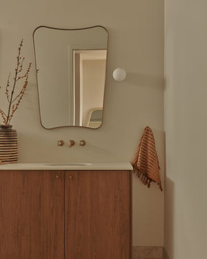 Warm bathroom featuring sphere wall sconce