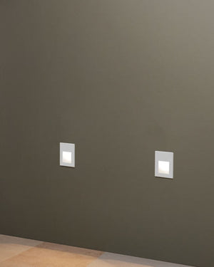 Two square wall lights on a dark gray wall.