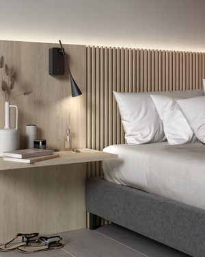 Modern bedroom with a bed, nightstand, and Skybell Plus A/01 wall-mounted lamp.